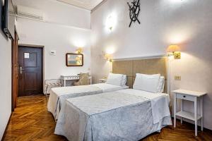 佛罗伦萨亚历山德拉酒店的酒店客房设有两张床和一张桌子。
