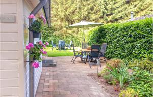 福尔登Stunning Home In Vorden With Wifi的庭院配有桌椅和遮阳伞。