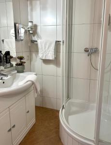 施泰格斯巴赫Landhotel Stegersbach的带淋浴和盥洗盆的白色浴室