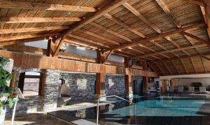 克莱恩 蒙塔纳埃特里耶酒店的一座带游泳池的房屋,位于带木制天花板的房间内