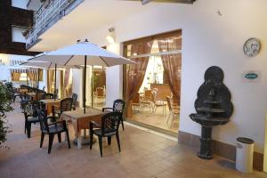 阿尔玛·迪·塔吉亚阿尔马餐厅酒店的餐厅设有桌椅和墙上的时钟