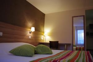 萨韦奈Logis Hotel Le Chêne Vert的配有两张绿色枕头的床的酒店客房