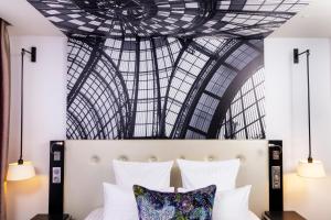 巴黎古斯塔夫酒店的一间卧室设有一张带大型天花板的床。