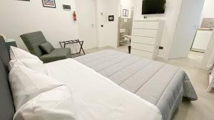 巴勒莫Palermo Central的白色卧室配有一张大床和椅子