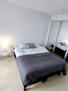 于韦斯屈莱Alvar, Tilava uusi kaksio ydinkeskustassa 53 m2的一间卧室配有一张床和一张带台灯的桌子