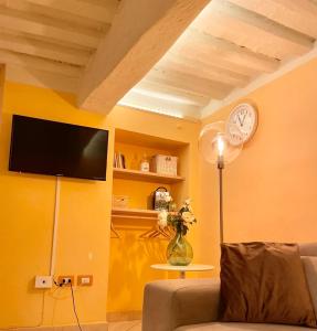 卢卡Piazza Napoleone Sweet apartment的客厅配有沙发和墙上的时钟