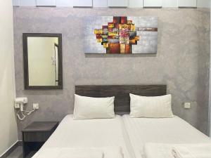 安顺MR Homestay HotelStyle Room Teluk Intan的卧室配有一张床,墙上挂有绘画作品