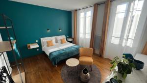 圣吉隆Jardin Bleu - Chambres d'hôtes的一间卧室设有一张床和蓝色的墙壁