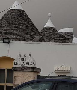 马丁纳弗兰卡Trullo della Rosa的停在大楼前的带有标志的汽车