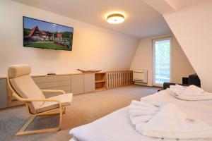 PodhorieChata Cementár的一间卧室设有两张床,墙上配有电视。