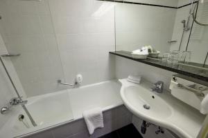 埃森佈雷登尼酒店的带浴缸、水槽和镜子的浴室