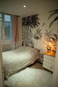 尚贝里Hypercentre Chambéry的卧室配有一张床,墙上种植了棕榈树