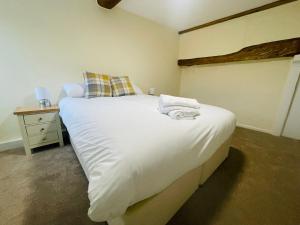 图克斯伯里The Royal Oak的卧室配有一张带白色床单和枕头的大床。