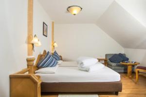 拉古多阿尔伯格切尔沃港和森酒店的一间卧室配有带白色床单和枕头的床。