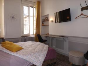 富热尔Chambre d'hôtes LARIBOISIERE的一间卧室配有一张床、一张书桌和一台电视