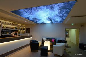圣谢利达普谢贝尔地平线酒店的一间酒吧,天花板上种有树木