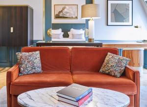 巴黎Grand Powers Hotel的客厅配有一张沙发,桌子上摆放着书籍