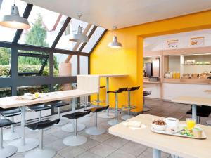 科尔马hotelF1 Colmar Parc des Expositions的厨房拥有黄色的墙壁和桌椅