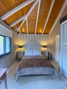 普拉泽里什Casa de Prazeres的一间卧室配有一张大床、两张桌子和两盏灯。