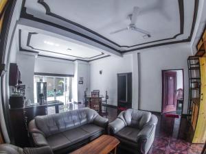 康提Kandy Forest Villa Hotel的客厅配有两张真皮沙发和一张桌子