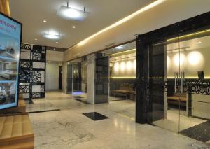 孟买Hotel Diplomat, Colaba的大厅,设有玻璃门和长凳
