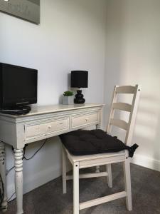 约克York City Homestays的一张椅子,坐在一张桌子前,配有一台电脑