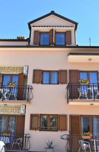罗维尼Apartments & Rooms Ivana的一座带窗户和桌椅的阳台的建筑