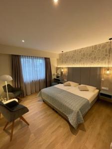 库克斯港斯特兰德胡斯酒店的一间卧室配有一张大床和一把椅子
