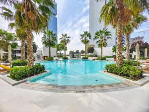 迪拜Luxury Studio with Pool View in Vibrant Community的一座棕榈树游泳池