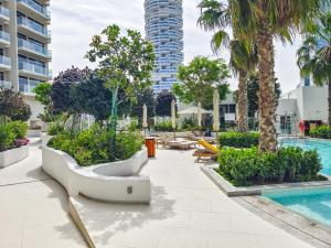 迪拜Luxury Studio with Pool View in Vibrant Community的树木和游泳池度假村的游泳池