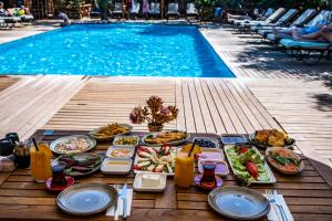 博德鲁姆Dolce Vita Luxury Bungalows的游泳池旁带食物的桌子