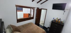 瓜塔维塔HOSPEDAJE DE GUATAVITA的一间配有沙发、窗户和电视的客房