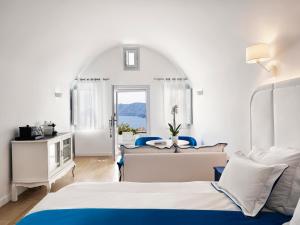 伊亚Katikies Santorini - The Leading Hotels Of The World的酒店客房设有两张床和窗户。