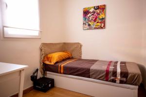 马德里De El Retiro al cielo的小卧室配有带橙色枕头的床