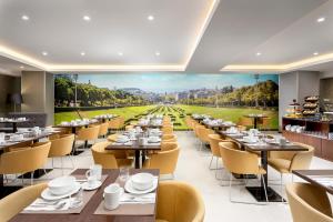 里斯本Empire Marquês Hotel的一间带桌椅的用餐室和一幅体育场画
