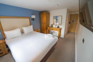 曼彻斯特水边酒店和休闲俱乐部的卧室配有一张白色大床和镜子