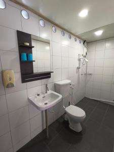 刁曼岛Tiongman Scubadive & Lodge的白色的浴室设有卫生间和水槽。