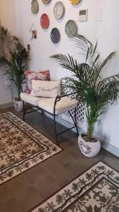 赫雷斯-德拉弗龙特拉La Gitanilla Alojamiento & Encanto Jerez的带沙发、植物和地毯的客厅