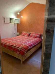 塞里纳Paradise La Tana的一间卧室配有一张带红色铺面毯子的床