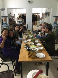 Văn LâmTam Coc Scenery Homestay的一群坐在桌子旁吃食物的人
