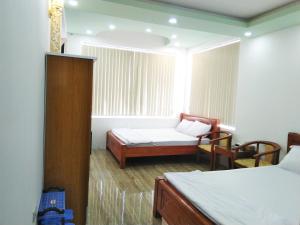 Ấp Trà KhaKhách sạn Gia Nghiêm的小房间设有两张床和窗户