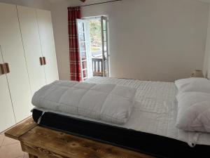 塞里纳Camera matrimoniale con terrazza panoramica的一间卧室配有一张带白色床单的床和一扇窗户。