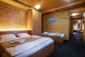 斯塔拉·里斯拉Chata Pri potoku的木制客房内的一间卧室配有两张床