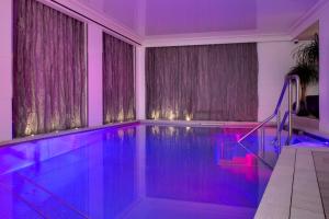 巴黎奥斯曼别墅酒店的一座房子内带紫色照明的游泳池