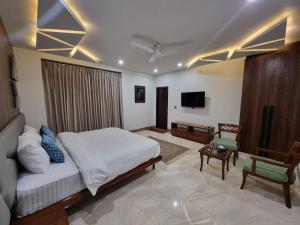 奎达Grand Hotel Quetta的一间卧室设有一张床,客厅设有电视。