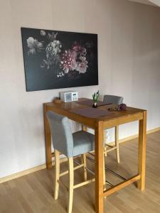 诺特海姆Ferienwohnung Seeblick的一张带两把椅子的木桌和墙上的一幅画