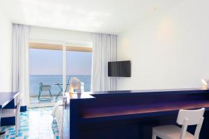 帕利努罗萨林恩酒店的客房设有书桌,享有海景。