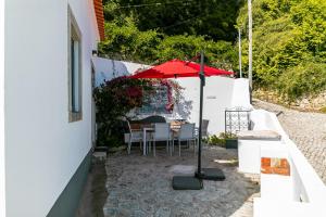 辛特拉Casota - Lusitália Eden的一个带桌子和遮阳伞的庭院