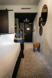 法尔肯堡Hotel Valkenburg by Mercure - Next to Shimano Experience Center的配有一张床和一把椅子的酒店客房