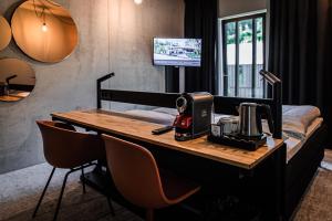 法尔肯堡Hotel Valkenburg by Mercure - Next to Shimano Experience Center的一间设有书桌的房间,上面有缝 ⁇ 机